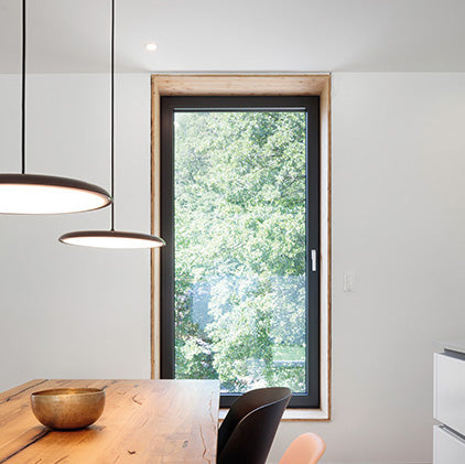 Fenêtres à triple vitrage avec ouvrants modernes, offrant isolation et luminosité dans une pièce à vivre