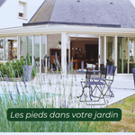 Véranda blanche moderne ouverte sur jardin avec des plants de lavande